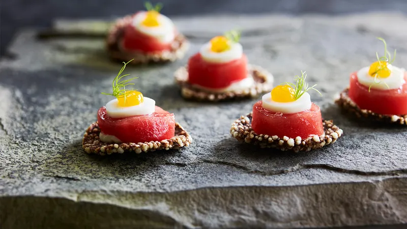Tuna canapés garnished with herbs on slate, catered by PEARL